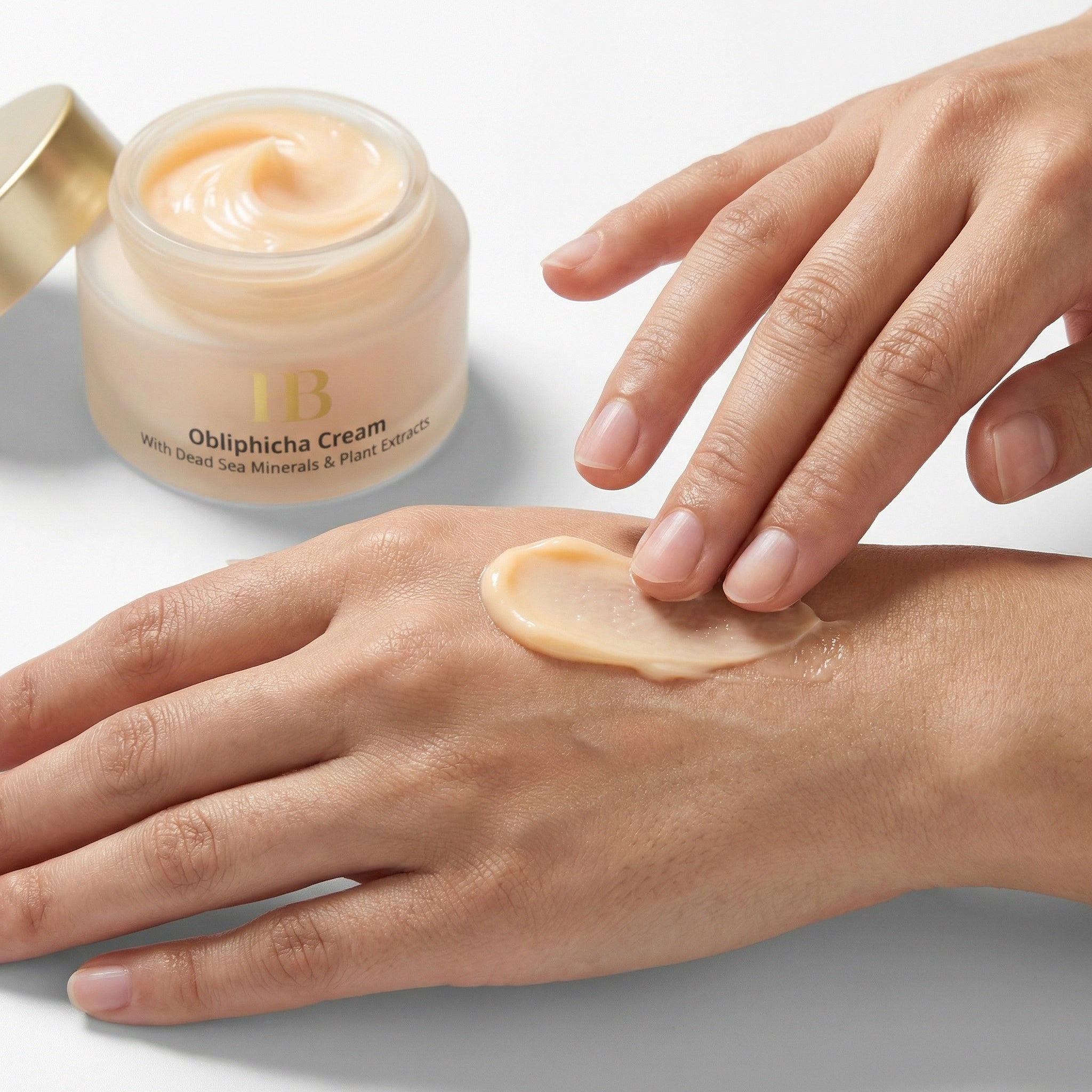 Person applying Obiphicha Cream to their wrist with a jar of the cream in the background.